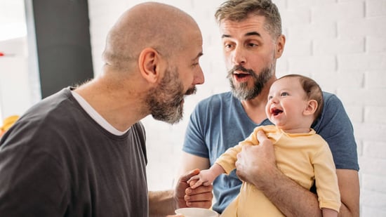 gay dads smiling at baby
