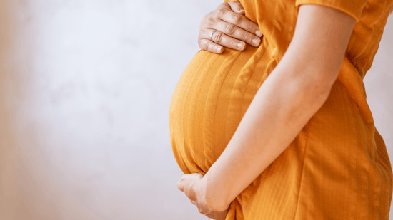 how much do surrogates make to carry a pregnancy pregnant woman in orange dress holding her pregnant belly