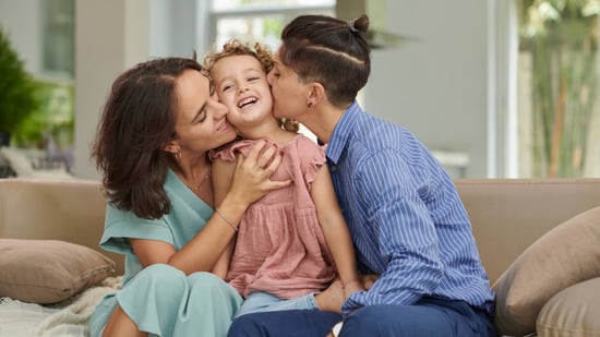 queer moms kissing daughter on cheeks