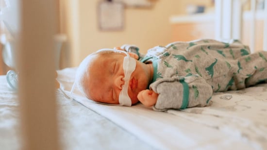 newborn baby in hospital laying in crib 