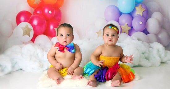 twin babies sitting in rainbow outfits 
